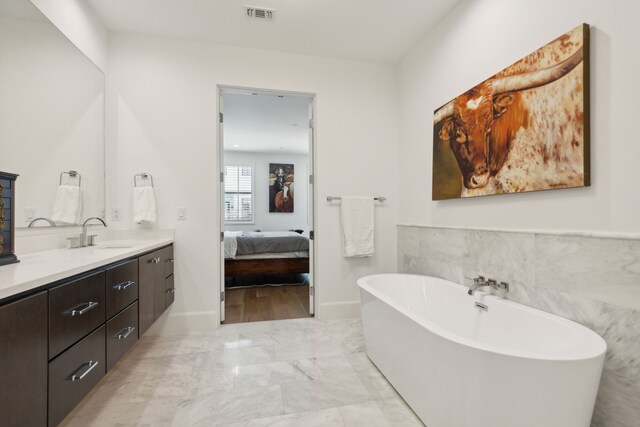 5270 Town And Country Blvd Unit 113, Frisco, TX 75034 - bathroom featuring visible vents, ensuite bathroom, marble finish floor, a freestanding bath, and vanity