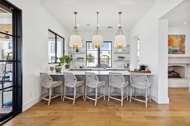 5270 Town And Country Blvd Unit 113, Frisco, TX 75034 - kitchen featuring light countertops, hanging light fixtures, a breakfast bar area, and open shelves