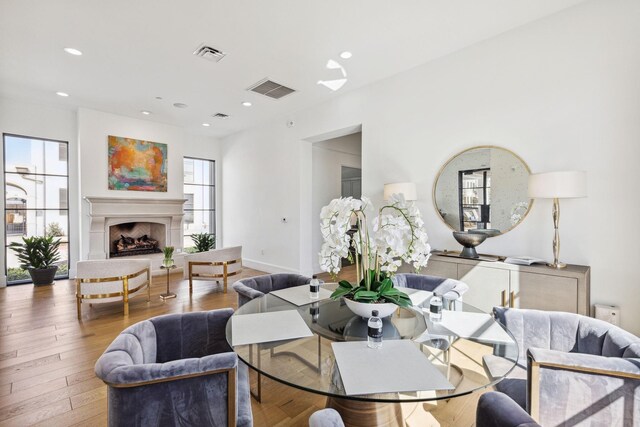 5270 Town And Country Blvd Unit 113, Frisco, TX 75034 - dining space featuring visible vents, a fireplace with raised hearth, and wood finished floors