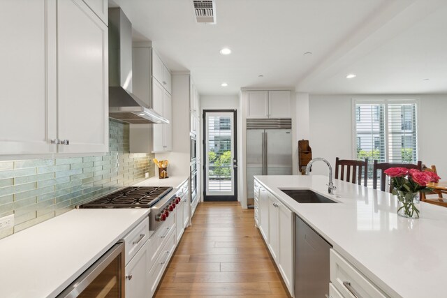 5270 Town And Country Blvd Unit 113, Frisco, TX 75034 - kitchen with a sink, white cabinetry, light countertops, appliances with stainless steel finishes, and wall chimney exhaust hood