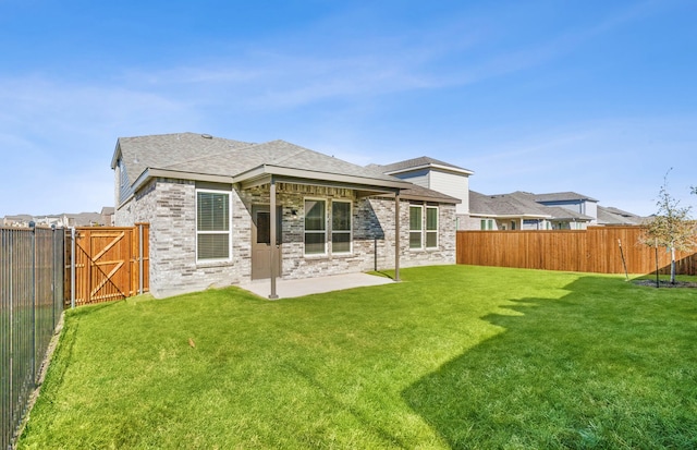 back of house with a yard and a patio