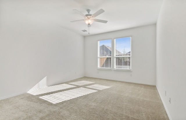 carpeted spare room featuring ceiling fan