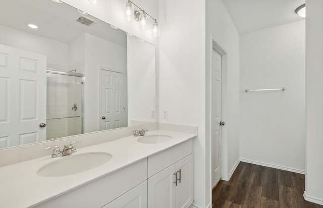 bathroom with a shower with door, vanity, and wood-type flooring