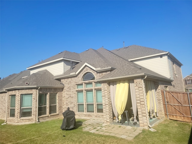 rear view of house with a lawn and a patio area