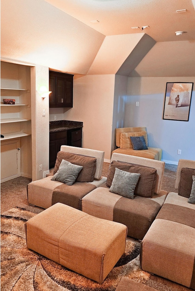 living room featuring carpet, built in shelves, and vaulted ceiling