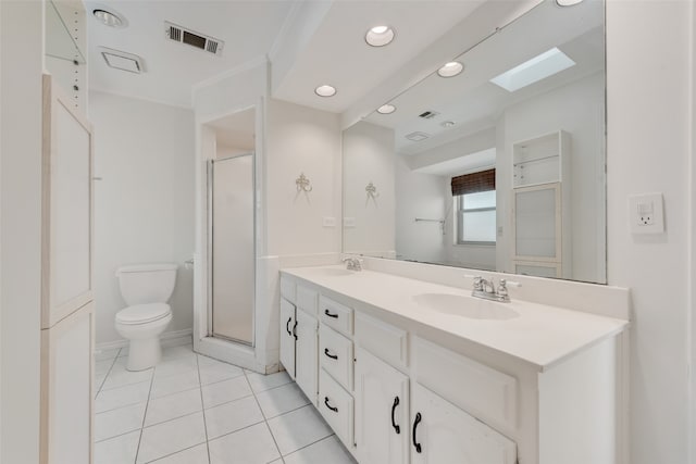 bathroom featuring a skylight, vanity, tile patterned floors, an enclosed shower, and toilet