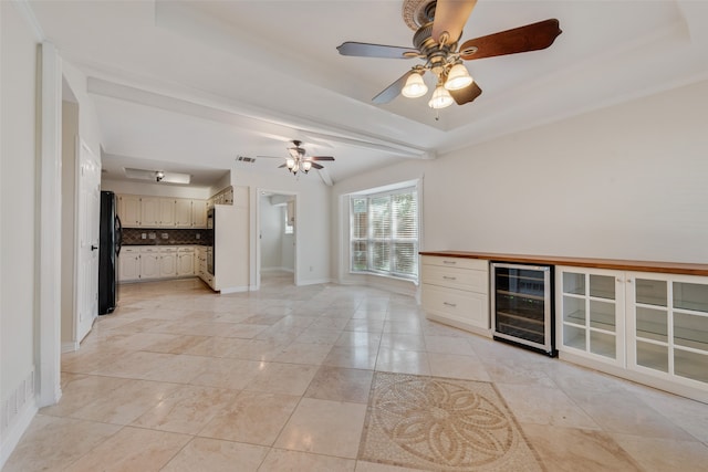 unfurnished living room with light tile patterned flooring, ceiling fan, a raised ceiling, and beverage cooler