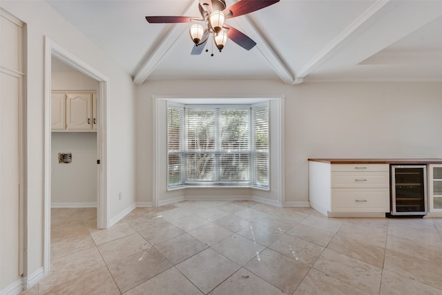 interior space featuring ceiling fan, light tile patterned floors, lofted ceiling with beams, and beverage cooler