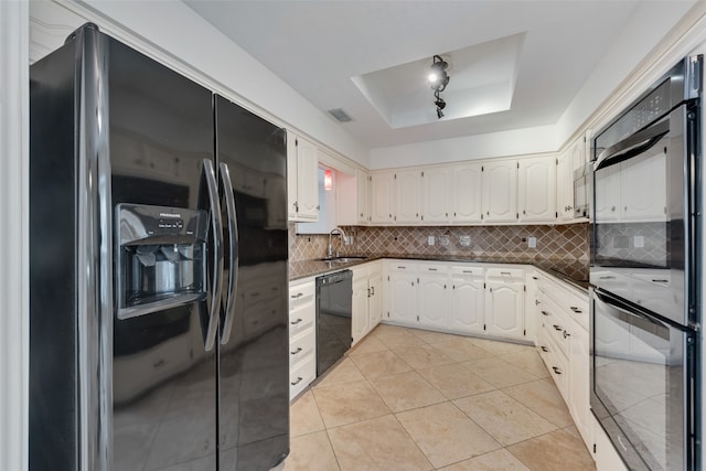 kitchen with sink, white cabinetry, a tray ceiling, light tile patterned floors, and black appliances