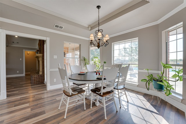 dining room featuring a chandelier, dark hardwood / wood-style flooring, and crown molding