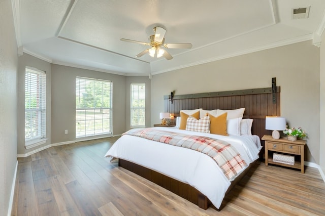 bedroom with crown molding, wood-type flooring, and ceiling fan