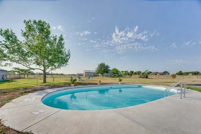 view of swimming pool with a yard