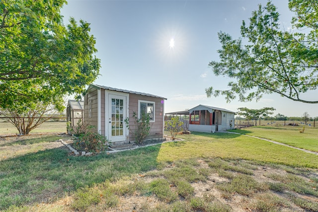 view of front of property featuring a front lawn and an outdoor structure