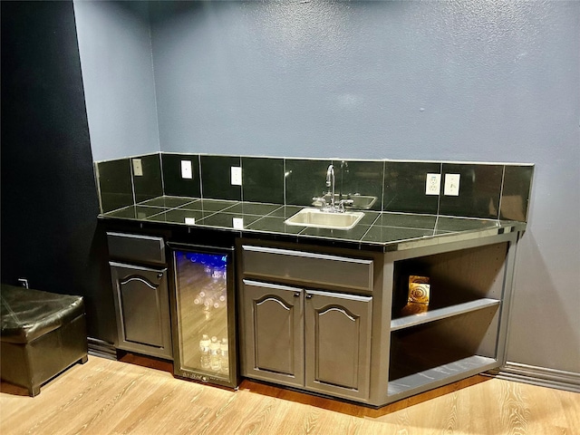 interior space with vanity, beverage cooler, and hardwood / wood-style floors