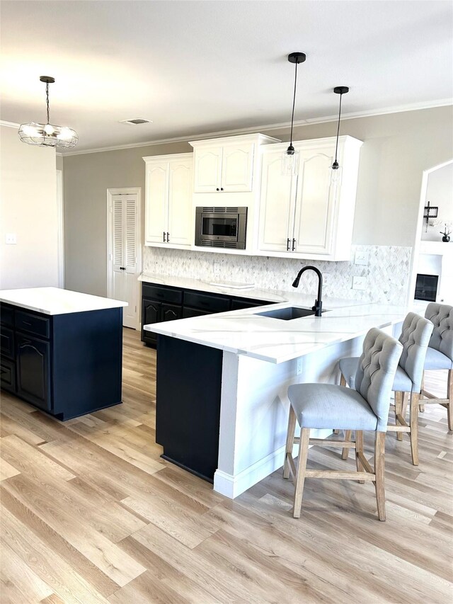 kitchen with tasteful backsplash, sink, beverage cooler, and light wood-type flooring