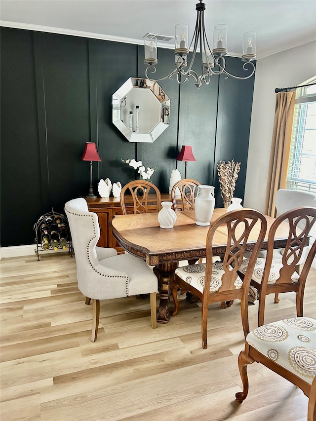 dining area with crown molding, wood-type flooring, and an inviting chandelier