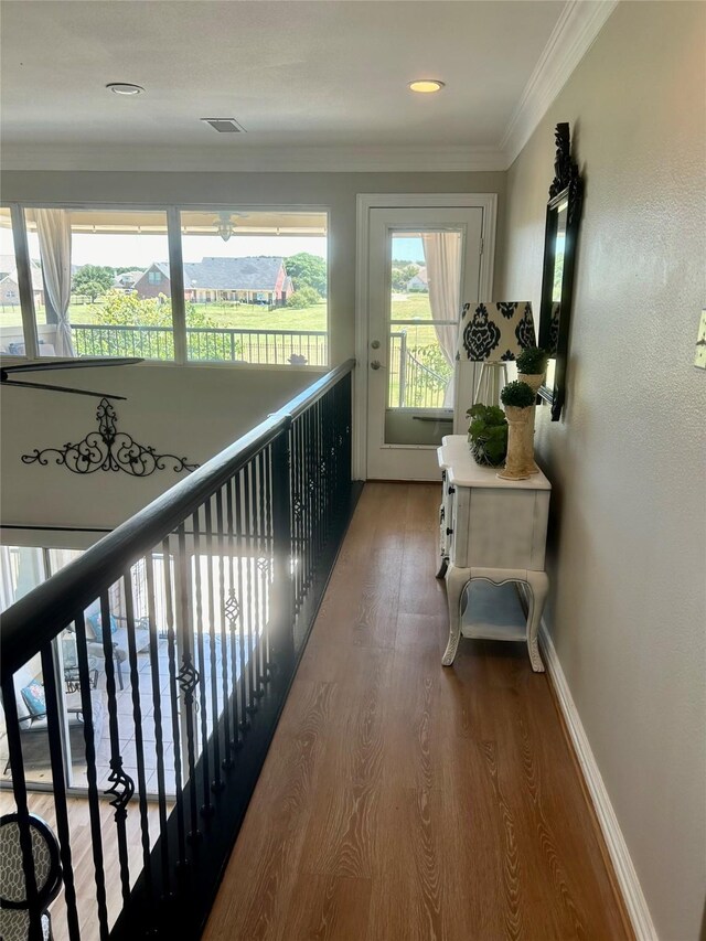 hall with hardwood / wood-style flooring and crown molding