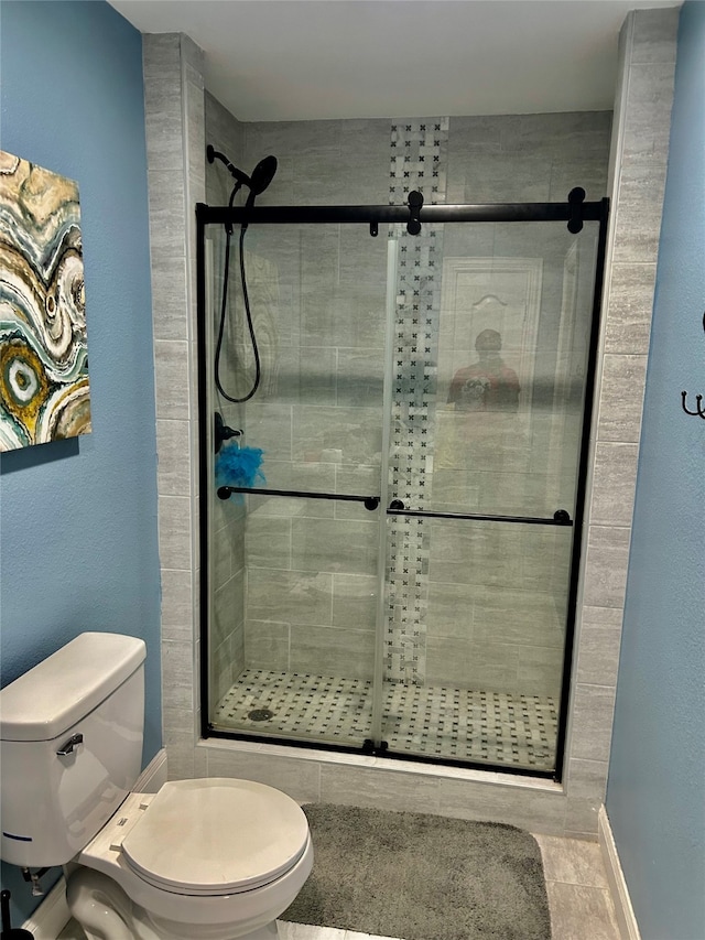 bathroom with walk in shower, tile patterned flooring, and toilet