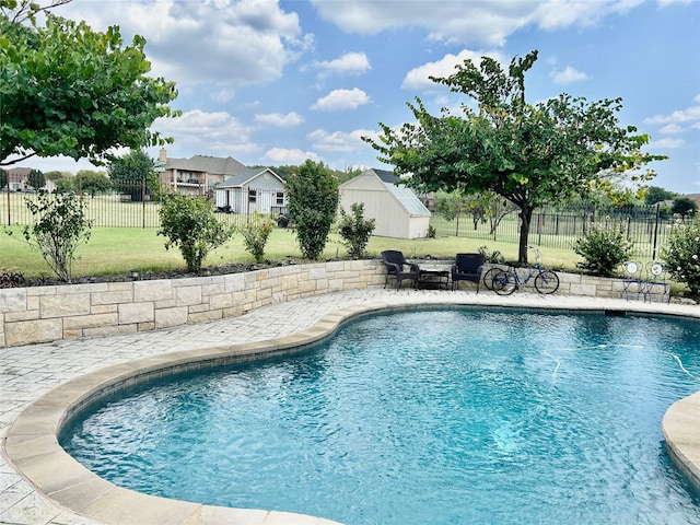 view of pool featuring a storage unit and a lawn