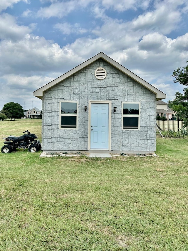 view of front of house featuring a front lawn and an outdoor structure