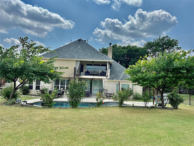 back of house with a yard, a balcony, and a patio area