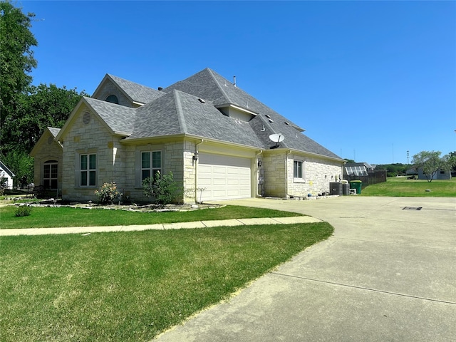 view of side of home with a garage, central AC unit, and a lawn