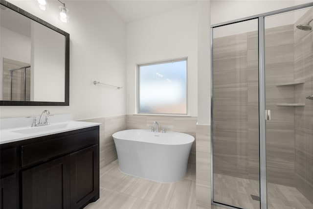 bathroom featuring vanity, tile patterned floors, tile walls, and separate shower and tub