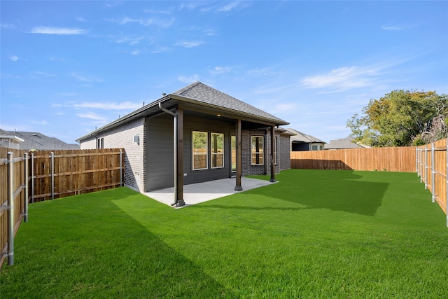 rear view of property with a patio and a lawn