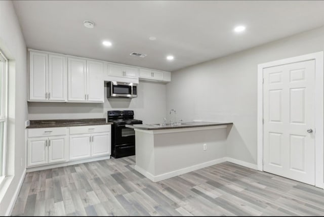 kitchen with black / electric stove, white cabinets, kitchen peninsula, and light hardwood / wood-style floors