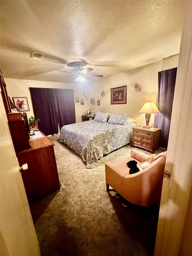 carpeted bedroom with ceiling fan and a textured ceiling