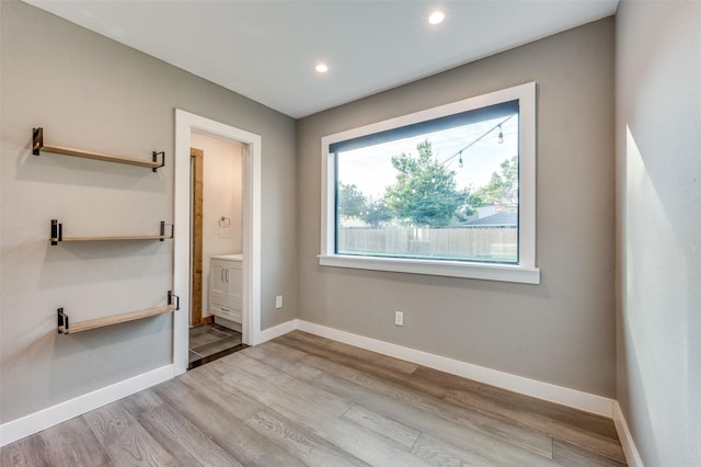 unfurnished bedroom featuring connected bathroom and light hardwood / wood-style floors