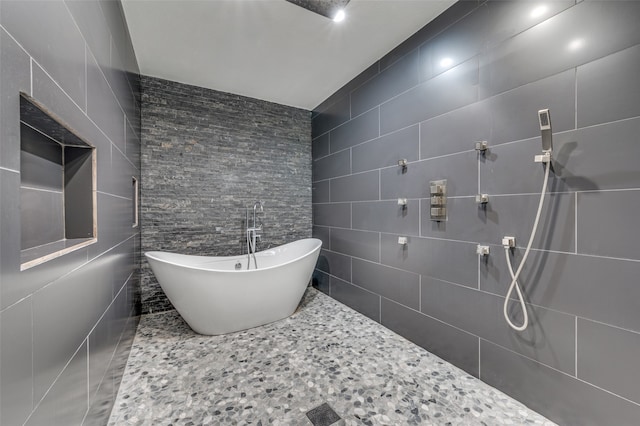 bathroom with tile walls and separate shower and tub