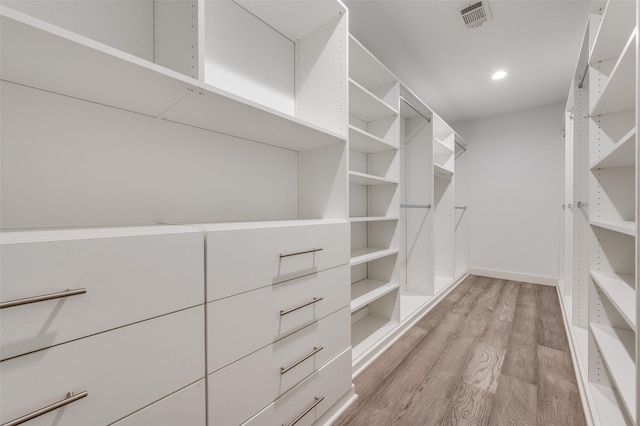 walk in closet with light hardwood / wood-style flooring