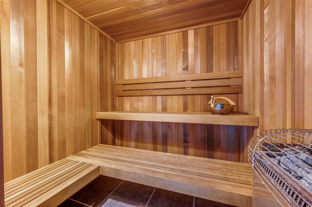 view of sauna featuring wood ceiling, tile patterned flooring, and wooden walls