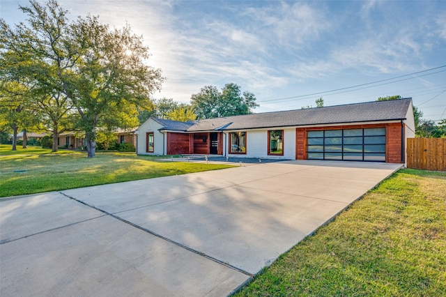 single story home featuring a garage and a front yard