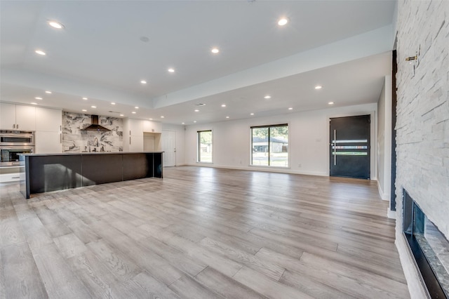 unfurnished living room featuring a fireplace and light wood-type flooring