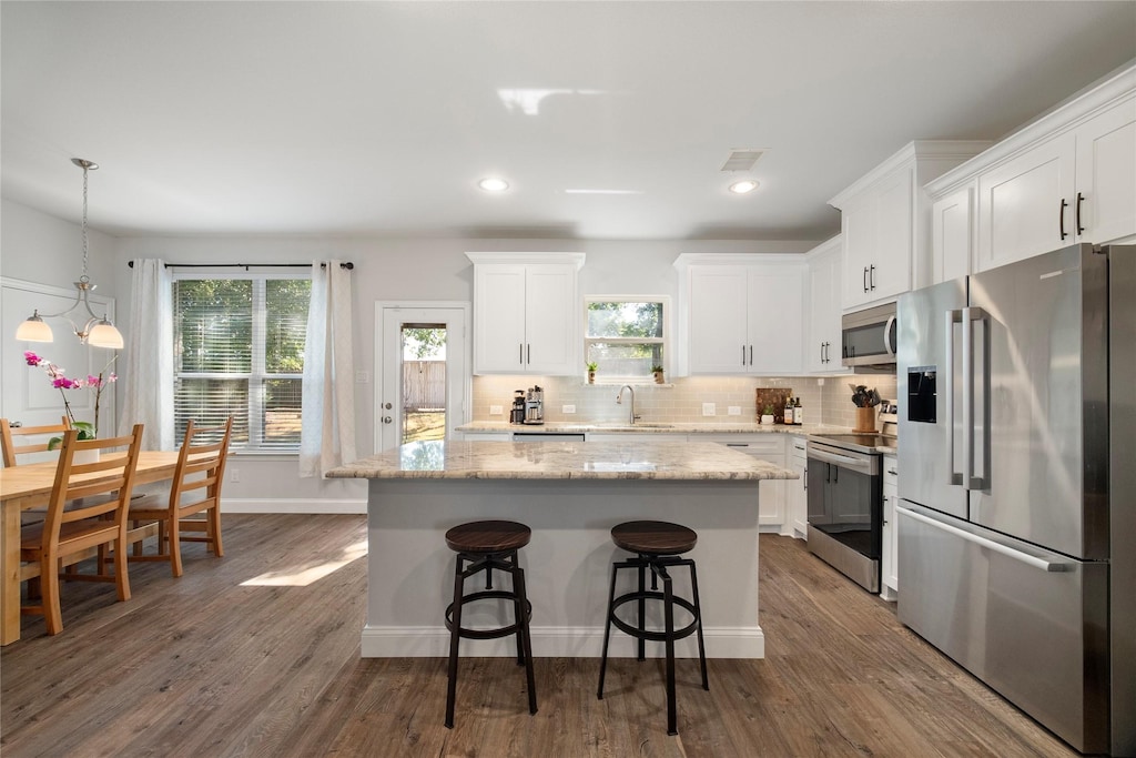 kitchen featuring appliances with stainless steel finishes, a center island, sink, and white cabinets