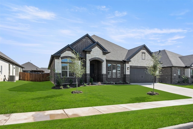 french country home featuring cooling unit, a garage, and a front lawn