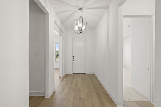 entryway with an inviting chandelier and light wood-type flooring