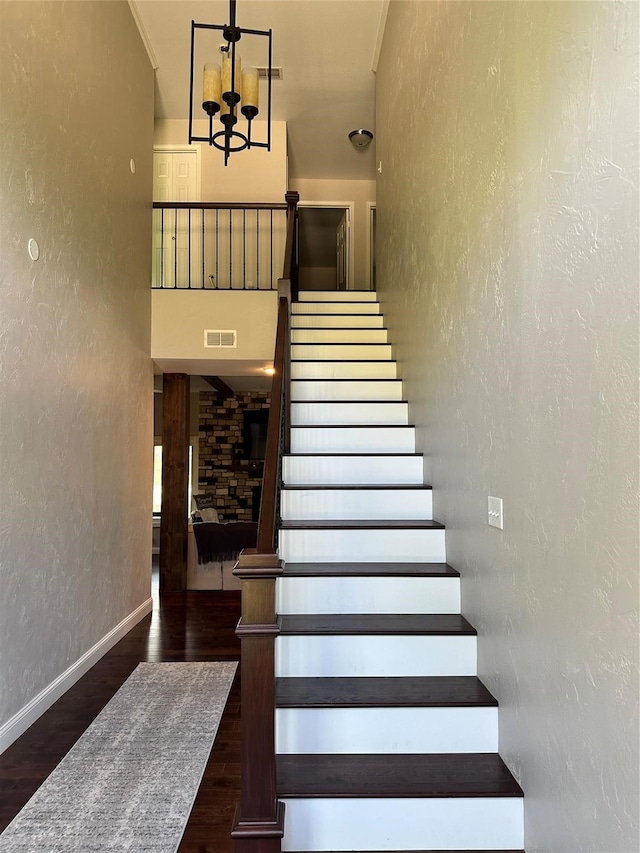 stairway featuring an inviting chandelier and hardwood / wood-style flooring