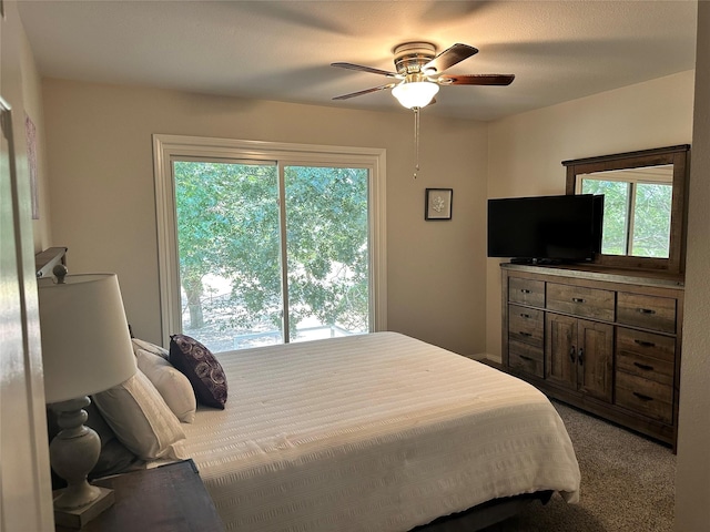 bedroom featuring ceiling fan, multiple windows, and carpet flooring