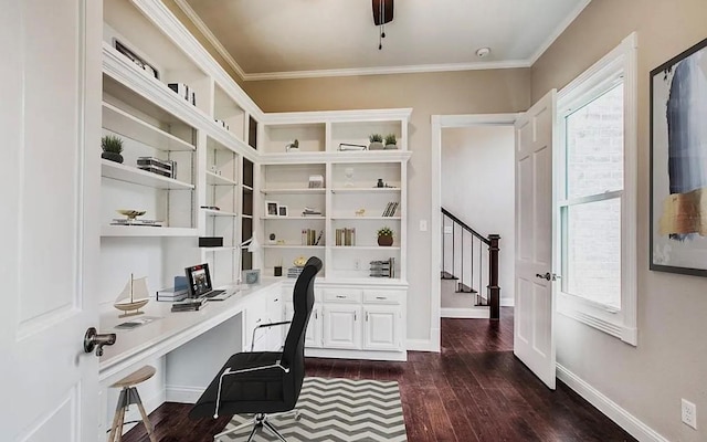 office with dark wood-type flooring, built in desk, and ornamental molding