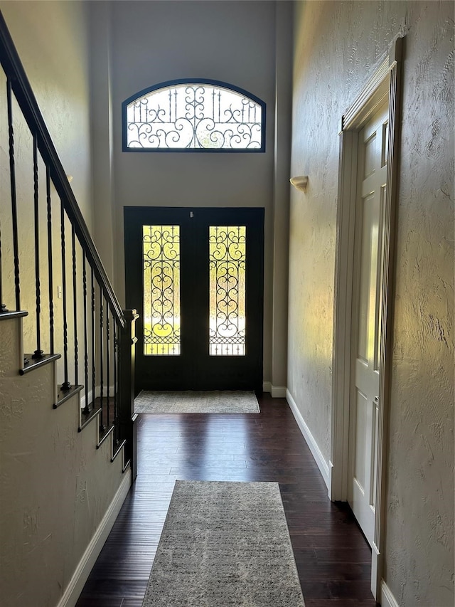 entryway with a high ceiling and dark hardwood / wood-style floors