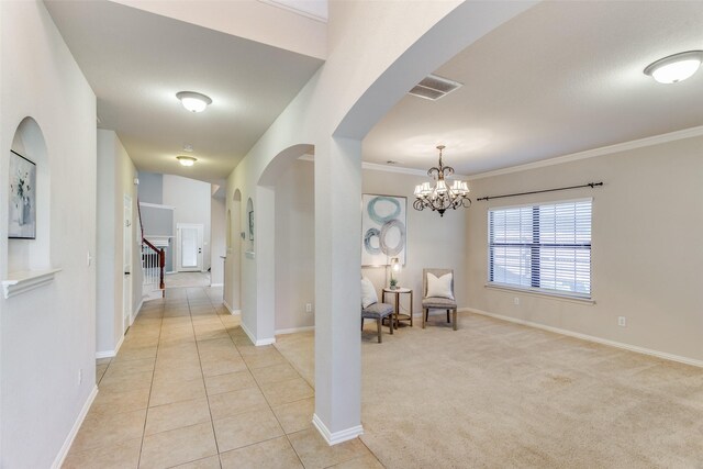 hall featuring a notable chandelier, crown molding, and light carpet