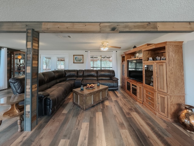 living room with light wood-type flooring, ceiling fan, crown molding, and a textured ceiling