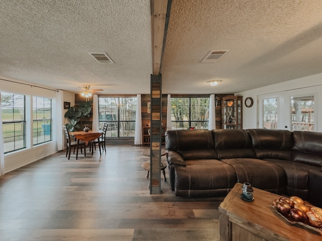 kitchen with stainless steel fridge, a breakfast bar area, wood-type flooring, and a textured ceiling