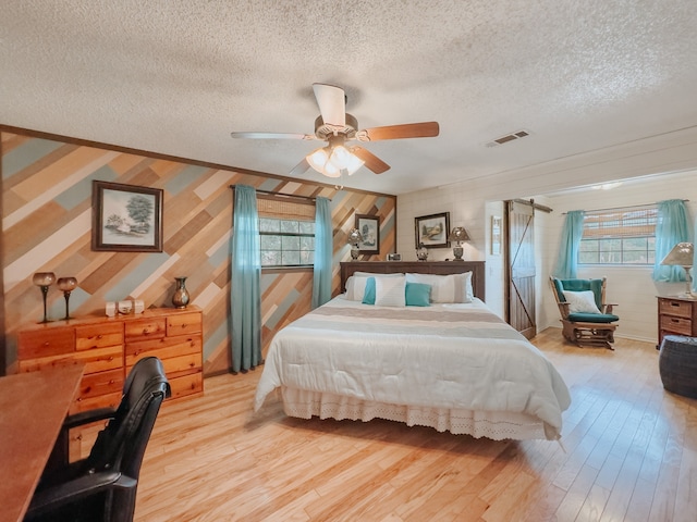 kitchen featuring pendant lighting, a textured ceiling, dark hardwood / wood-style flooring, light stone countertops, and appliances with stainless steel finishes