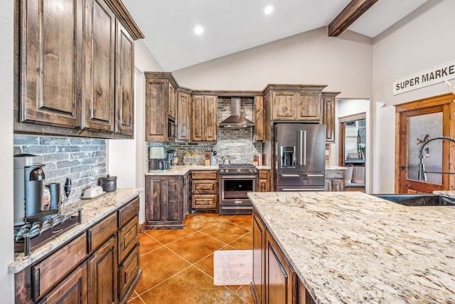 kitchen featuring appliances with stainless steel finishes, lofted ceiling with beams, backsplash, wall chimney exhaust hood, and sink