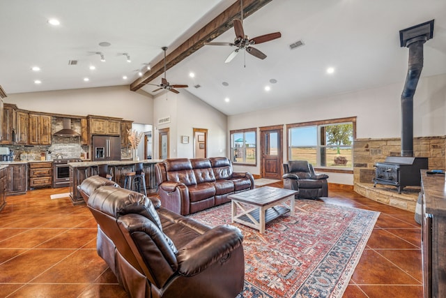 living room featuring beam ceiling, ceiling fan, dark tile patterned floors, and high vaulted ceiling