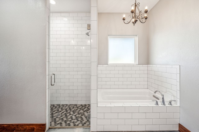 bathroom featuring a notable chandelier and separate shower and tub